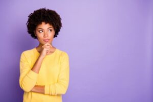 woman-wearing-yellow-shirt-thinking-with-purple-background